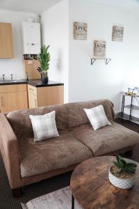 布赖尔利希尔2 Bedroom Apartment Brierley Hill的客厅配有棕色沙发和桌子
