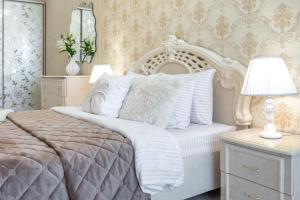 敖德萨Красивая квартира в ЦЕНТРЕ Одессы的卧室配有白色的床和带台灯的桌子