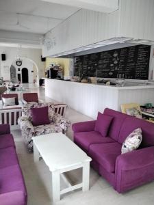 米尔托斯埃斯佩利兹酒店的客厅配有紫色沙发和台面