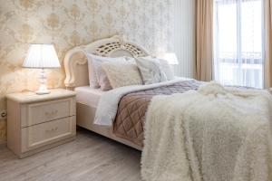 敖德萨Красивая квартира в ЦЕНТРЕ Одессы的卧室配有白色的床、灯和窗户。