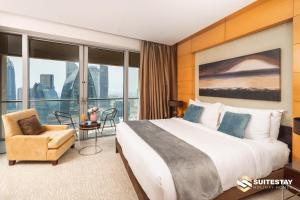 迪拜OSTAY -Address Dubai Mall - The Residence的酒店客房带一张大床和一把椅子