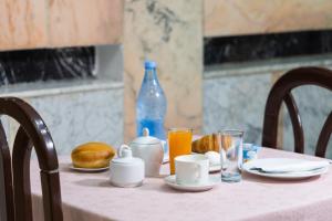 突尼斯Hôtel le passage的一张桌子,上面有粉红色的桌布,上面有食物和饮料