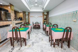 突尼斯Hôtel le passage的餐厅设有粉色和绿色的桌椅