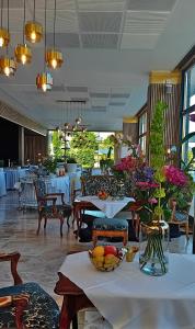 沃尔特湖畔韦尔登韦尔登网球&游艇酒店的餐厅设有桌椅和鲜花,