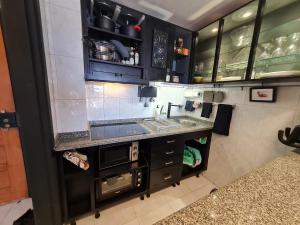 卡帕里卡海岸Beach Addiction的厨房配有黑色橱柜和水槽