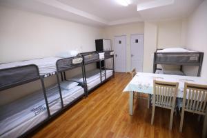 乌兰巴托Alpha Guest House的客房设有两张双层床和一张桌子。