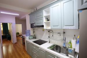 乌兰巴托Alpha Guest House的厨房配有白色橱柜和水槽