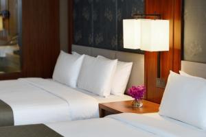 淡水福容大饭店淡水渔人码头的酒店客房,设有两张床和一张鲜花桌。