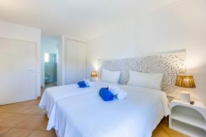 拉戈斯图里斯提克斯维拉帕尔梅拉公寓酒店的卧室配有白色的床,上面有蓝色填充动物
