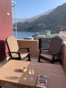 PaulTienne Del Mar的阳台上的桌椅和一杯葡萄酒