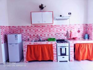 萨尔雷aparthotelboavistacom的厨房拥有粉红色和红色的瓷砖墙壁
