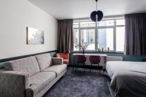 布鲁塞尔Hey - Aparthotel Brussels的客厅配有沙发和1张床