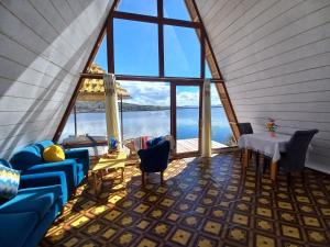 普诺Luna Titicaca Bungalows的客房设有大窗户、桌子和椅子。