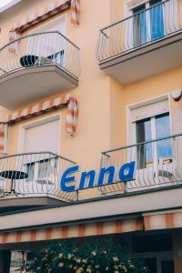 里米尼Hotel Enna Rimini的建筑一侧的标志,带有阳台