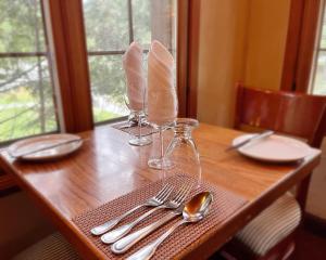圣阿黛拉奥伯格高山酒店的一张木桌,上面有盘子和银器