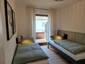 维林根Haus Daut的带窗户的客房内的两张床