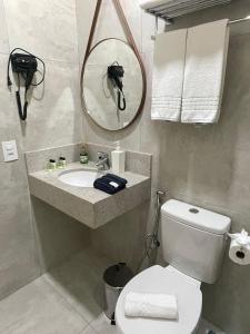 阿瓜斯迪林多亚Pousada Thermas das Montanhas的一间带卫生间、水槽和镜子的浴室