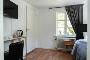 långstorp的一间卧室配有一张床、一张书桌和一个窗户。
