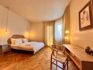 布加勒斯特City Center Unirii Square Private rooms with City View - Shared Amenities的配有一张床和一张书桌的酒店客房