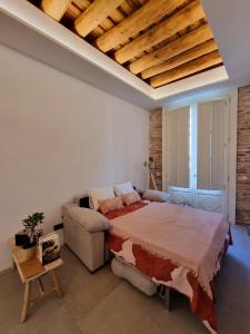 布拉内斯Antiquari de Blanes Apartamento rústico modernizado en la Costa Brava的一间卧室配有一张大床和一张沙发