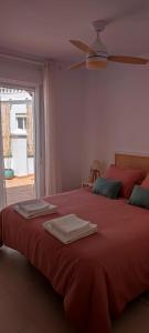 孔佩塔Ático jacuzzi Cómpeta的一间卧室配有红色的床和毛巾