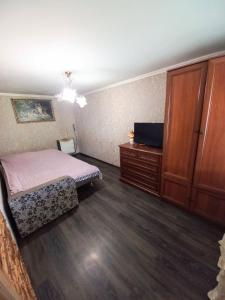 亚列姆切Котедж "Гірський Затишок"的一间卧室配有一张床、梳妆台和电视。