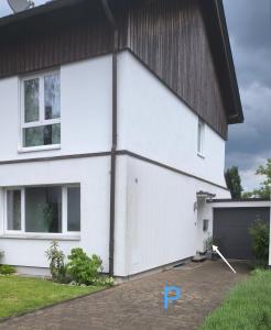 鲁尔河畔米尔海姆Dohlennest, helle moderne Wohnung für 4 Personen的黑色屋顶的白色房子