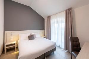 卡斯特莱奥内凯撒罗桥酒店的配有一张床和一把椅子的酒店客房