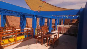 阿里卡Raymi House Hostel的阳台的蓝色帐篷,配有桌椅