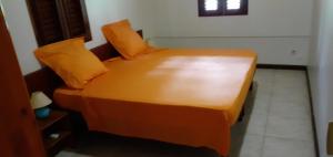 Gros-MorneMaison de 2 chambres avec terrasse amenagee et wifi a Gros Morne的一张带橙色枕头的床