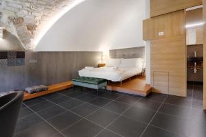 拉古萨Itria Palace的一间卧室配有一张床,卧室配有长凳