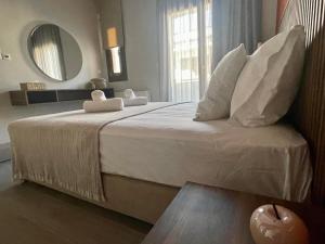 伊里斯斯Αura Luxury Apartments的一间卧室配有一张带镜子的大床