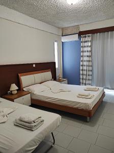 毕达哥利翁Oceanida Bay Hotel的一间卧室设有两张床和窗户。