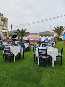 毕达哥利翁Oceanida Bay Hotel的一组坐在草地上的桌椅