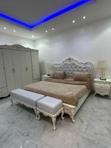 利雅德بيت النرجس الخاص的一间大卧室,配有一张蓝色天花板的大床