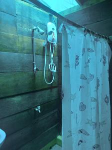 亭可马里塞拉小屋旅馆的挂在墙上的带吹风机的浴帘