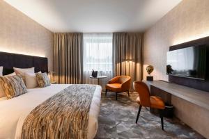 滑铁卢Van der Valk Waterloo的配有一张床和一台平面电视的酒店客房