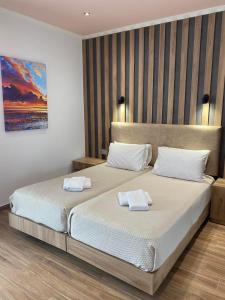 伊古迈尼察赛尔拉夫卡斯宫殿酒店的一间卧室配有两张带毛巾的床