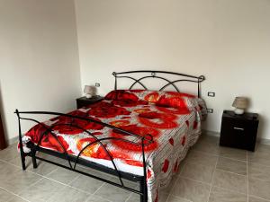 卡尔博尼亚Casa Lubiana的一间卧室配有一张红色棉被的床