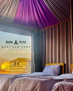 瓦迪拉姆Sunrise Wadi Rum Camp的一间卧室配有一张紫色天花板的床