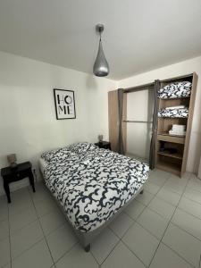 格里莫Appartement de charme n7的一间卧室配有一张带黑白色棉被的床