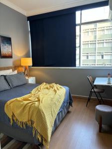 里约热内卢LGBT Friendly - Quarto em Ipanema Posto 9 - Casa de Vitor e Carlos的一间卧室配有一张床、一张书桌和一个窗户。