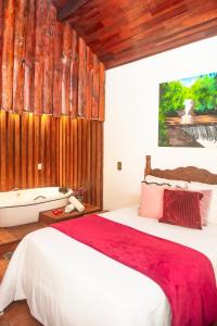 蒙特韦尔迪Chalés Recanto da cachoeira的一间卧室设有一张大床和木墙