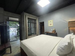 圣卡洛斯San Carlos Surf Resort & Eco Lodge的卧室配有白色的床和窗户。