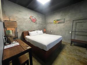 圣卡洛斯San Carlos Surf Resort & Eco Lodge的一间卧室配有一张床、一张桌子和一张四柱床。