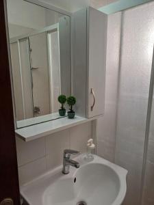 DumlupınarSUNFLOWER APARTMENT的白色的浴室设有水槽和镜子