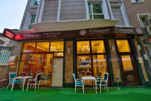 伊斯坦布尔Glamour Hotel Istanbul Sirkeci的大楼前设有桌椅的餐厅