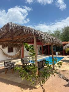 日若卡-迪热里科阿科阿拉Casa da Lagoa的一个带两个长椅的小屋,毗邻游泳池