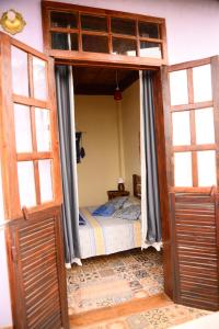 蒂拉登特斯Pousada Residência Balestra的一间卧室设有一张带床铺的开放式门