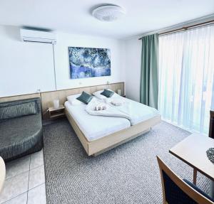 梅杜林Villa Osipovica的一间卧室配有一张床、一张桌子和一张沙发